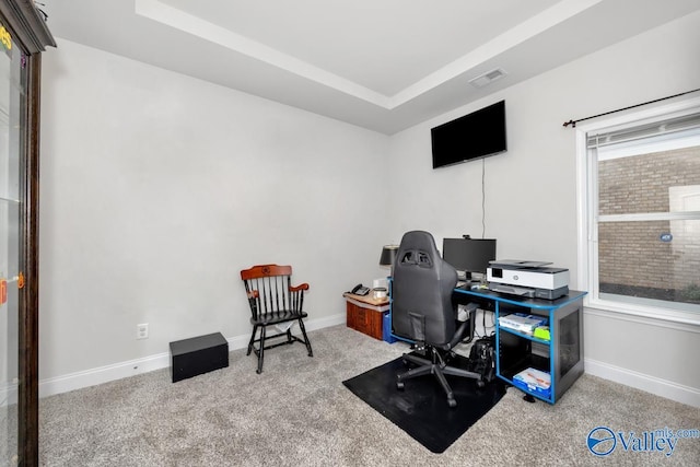 office area featuring a raised ceiling, visible vents, light carpet, and baseboards