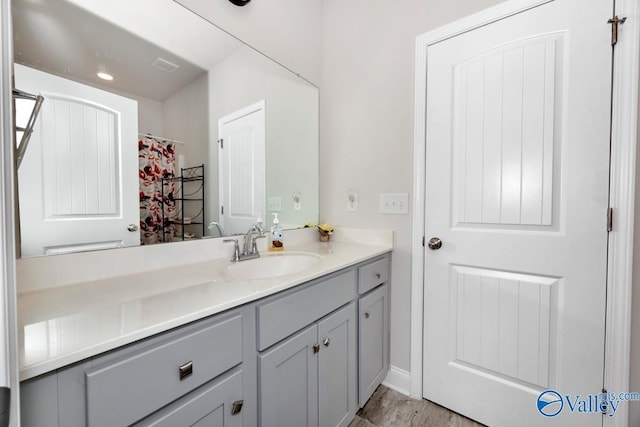 full bathroom with visible vents, vanity, and wood finished floors