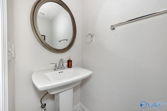 bathroom with a sink, visible vents, and baseboards