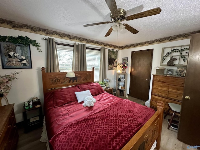 bedroom featuring hardwood / wood-style floors, ceiling fan, and a textured ceiling