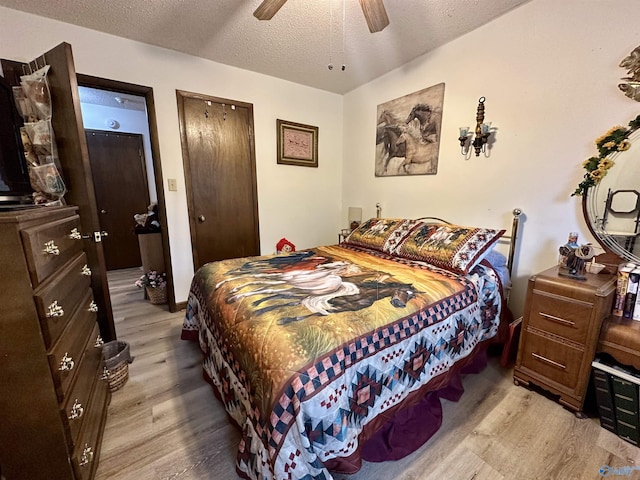 bedroom with ceiling fan, light hardwood / wood-style floors, and a textured ceiling