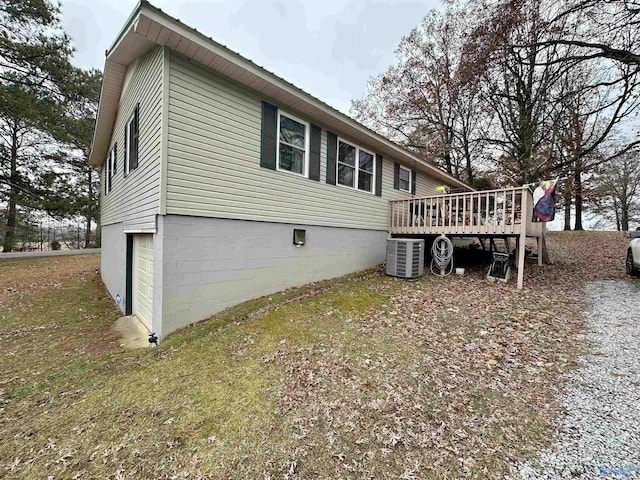 view of home's exterior with a garage, central AC unit, and a deck