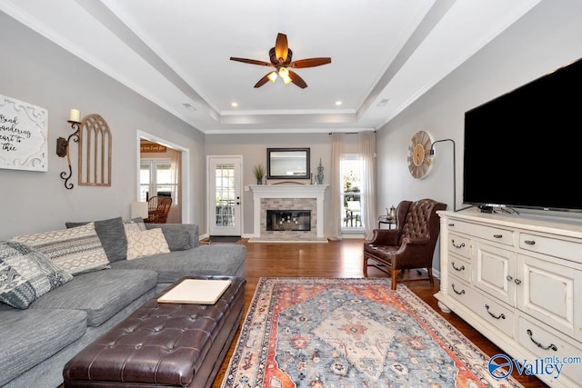 2609 Quarter Ln, Owens Cross Roads, AL 35763 - living area featuring a ceiling fan, wood finished floors, a glass covered fireplace, ornamental molding, and a tray ceiling