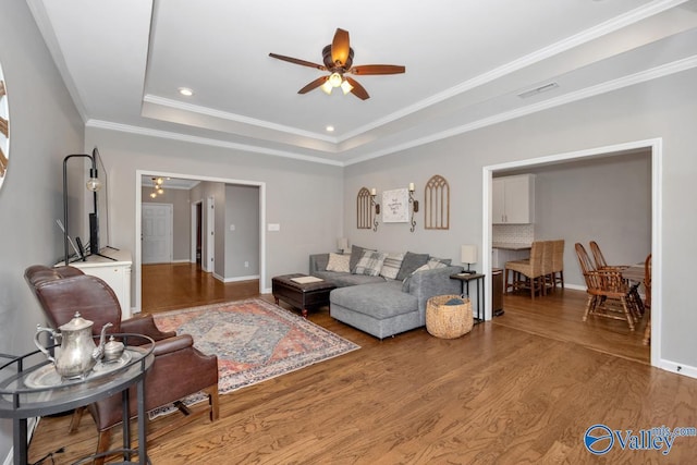 2609 Quarter Ln, Owens Cross Roads, AL 35763 - living area with crown molding, a raised ceiling, a ceiling fan, wood finished floors, and visible vents