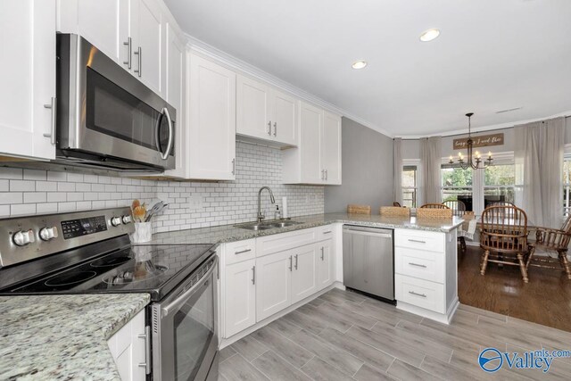 2609 Quarter Ln, Owens Cross Roads, AL 35763 - kitchen with a sink, stainless steel appliances, white cabinetry, and a chandelier