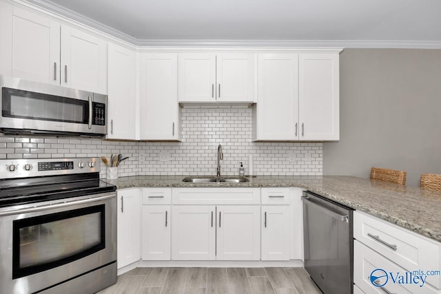 2609 Quarter Ln, Owens Cross Roads, AL 35763 - kitchen with a sink, white cabinets, light stone countertops, and stainless steel appliances