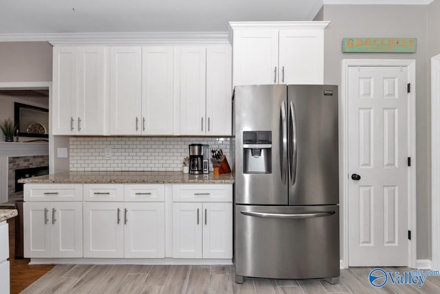 2609 Quarter Ln, Owens Cross Roads, AL 35763 - kitchen featuring stainless steel fridge, decorative backsplash, white cabinets, and light stone countertops