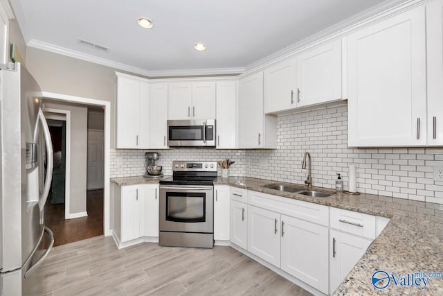 2609 Quarter Ln, Owens Cross Roads, AL 35763 - kitchen featuring crown molding, a sink, white cabinetry, and appliances with stainless steel finishes