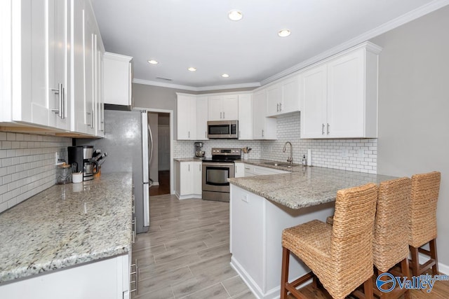 2609 Quarter Ln, Owens Cross Roads, AL 35763 - kitchen featuring backsplash, crown molding, appliances with stainless steel finishes, a sink, and a peninsula