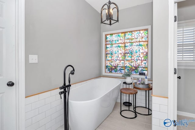 2609 Quarter Ln, Owens Cross Roads, AL 35763 - full bath featuring a freestanding bath, tile walls, wainscoting, and a chandelier