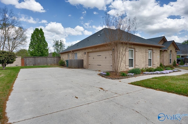 2609 Quarter Ln, Owens Cross Roads, AL 35763 - view of home's exterior featuring fence, brick siding, a shingled roof, concrete driveway, and an attached garage