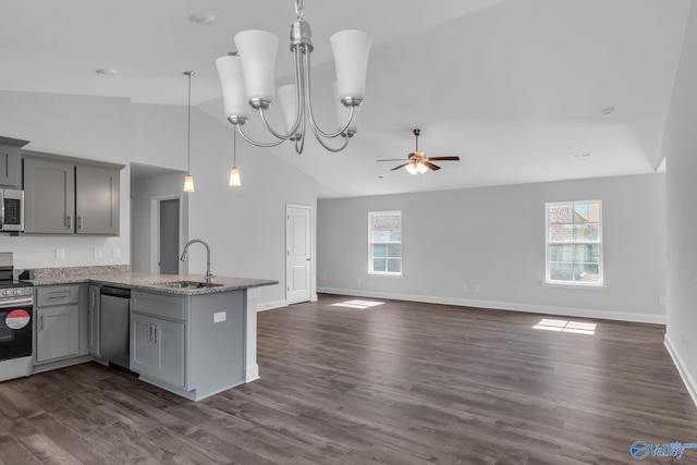 kitchen with pendant lighting, stainless steel appliances, gray cabinetry, open floor plan, and a sink