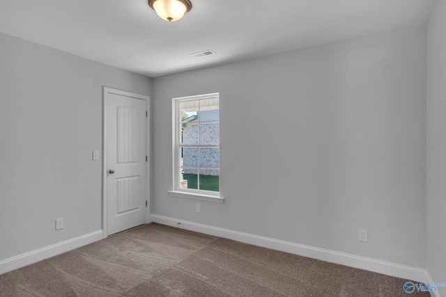 spare room with baseboards, visible vents, and light colored carpet