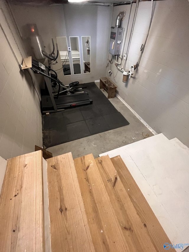 exercise room with concrete floors and tankless water heater