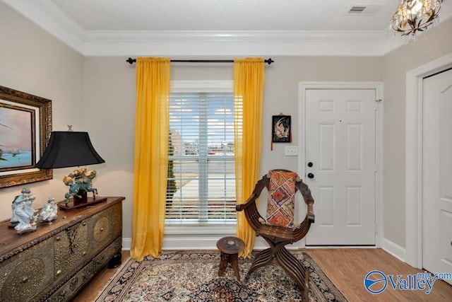 living area with hardwood / wood-style flooring and ornamental molding