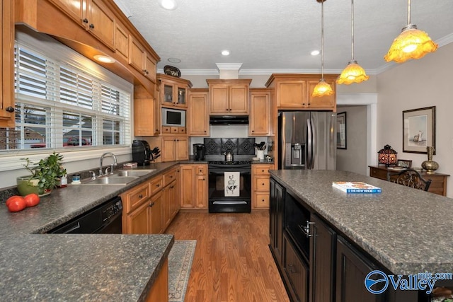 kitchen featuring sink, crown molding, hardwood / wood-style floors, hanging light fixtures, and black appliances