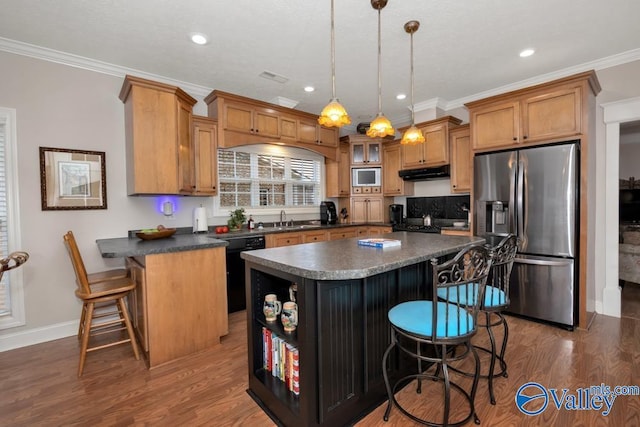 kitchen with pendant lighting, stainless steel appliances, a kitchen breakfast bar, a kitchen island, and dark hardwood / wood-style flooring