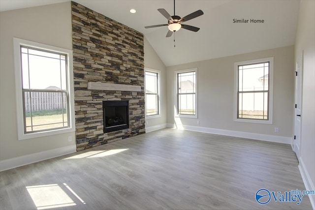 FLAGSTAFF-B Newby Chapel Rd, Athens, AL 35613 - unfurnished living room with a ceiling fan, a stone fireplace, wood finished floors, baseboards, and high vaulted ceiling
