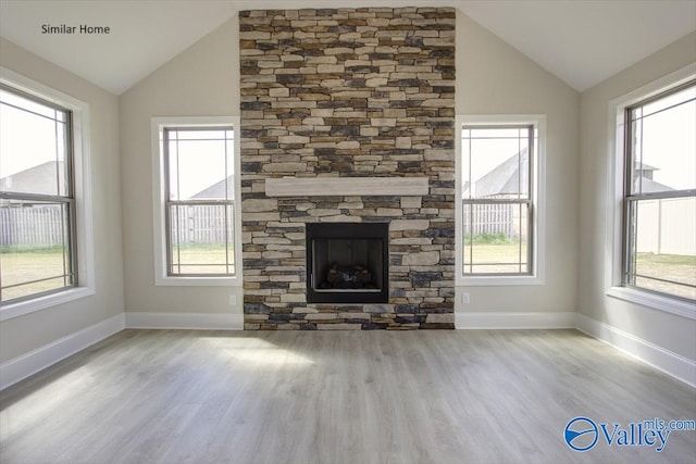 FLAGSTAFF-B Newby Chapel Rd, Athens, AL 35613 - unfurnished living room featuring vaulted ceiling, wood finished floors, healthy amount of natural light, a stone fireplace, and baseboards