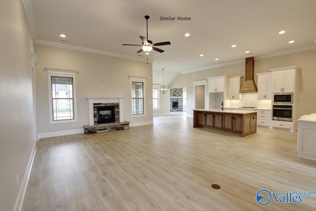 FLAGSTAFF-B Newby Chapel Rd, Athens, AL 35613 - unfurnished living room with a stone fireplace, baseboards, a ceiling fan, crown molding, and light wood-style floors