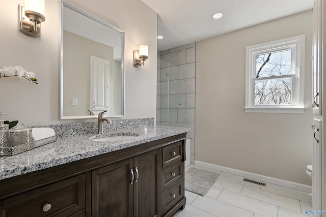 4018 SE Piedmont Dr, Huntsville, AL 35802 - bathroom featuring visible vents, baseboards, a tile shower, toilet, and vanity