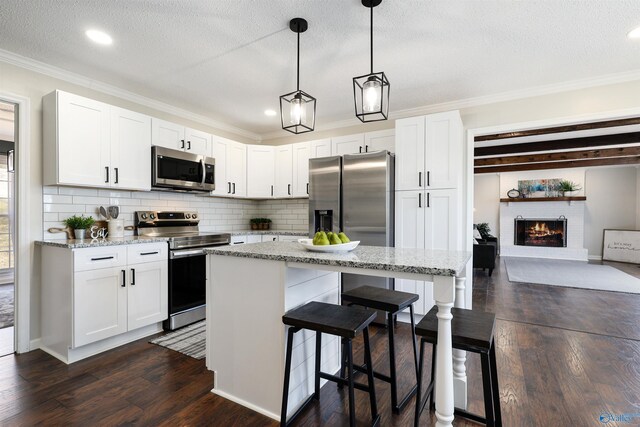4018 SE Piedmont Dr, Huntsville, AL 35802 - kitchen with tasteful backsplash, a breakfast bar, crown molding, a kitchen island, and stainless steel appliances