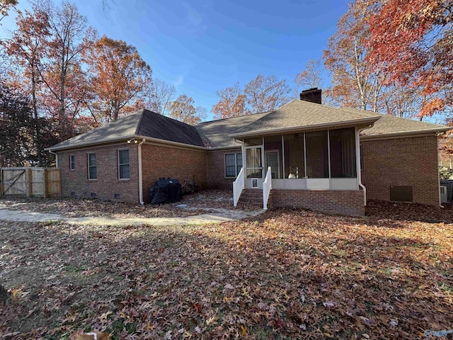 rear view of property featuring a sunroom