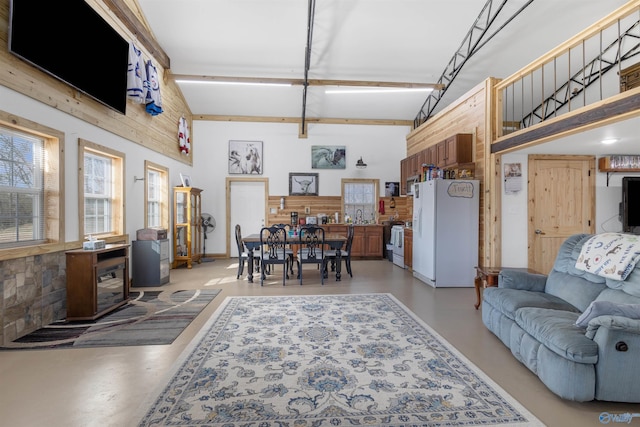 living room with plenty of natural light, a towering ceiling, and sink