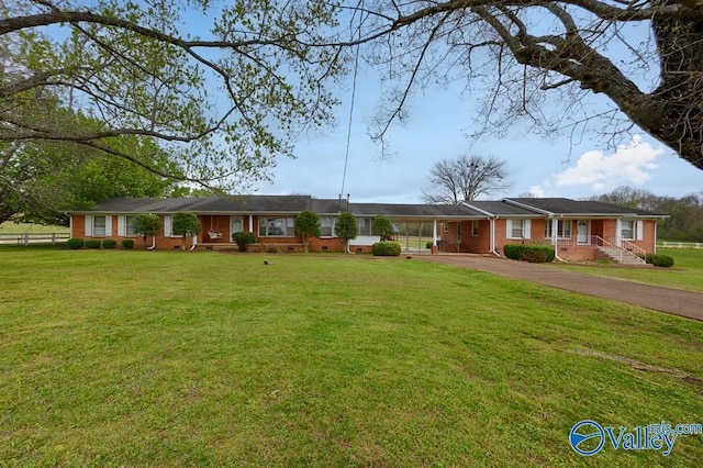 single story home with aphalt driveway, a front yard, and brick siding