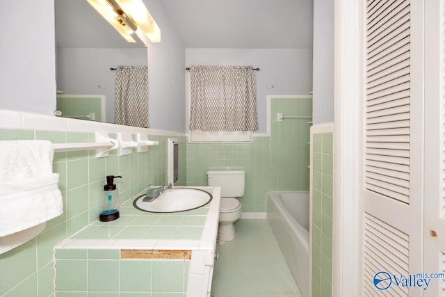 bathroom with vanity, tile patterned floors, toilet, and tile walls