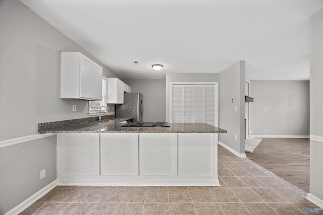 13935 SW Wyandotte Dr, Huntsville, AL 35803 - kitchen featuring freestanding refrigerator, dark stone counters, white cabinets, a peninsula, and black gas stovetop
