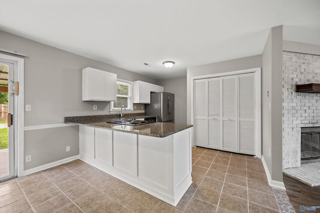 13935 SW Wyandotte Dr, Huntsville, AL 35803 - kitchen with freestanding refrigerator, dark stone countertops, white cabinetry, and healthy amount of natural light