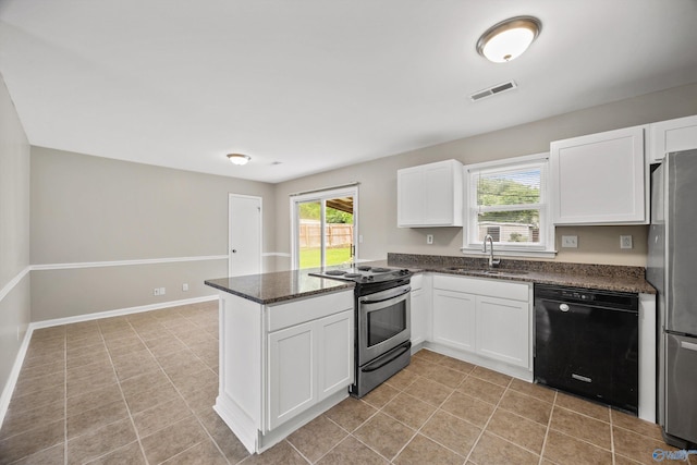 13935 SW Wyandotte Dr, Huntsville, AL 35803 - kitchen featuring stainless steel appliances, a peninsula, white cabinets, dark stone counters, and light tile patterned floors