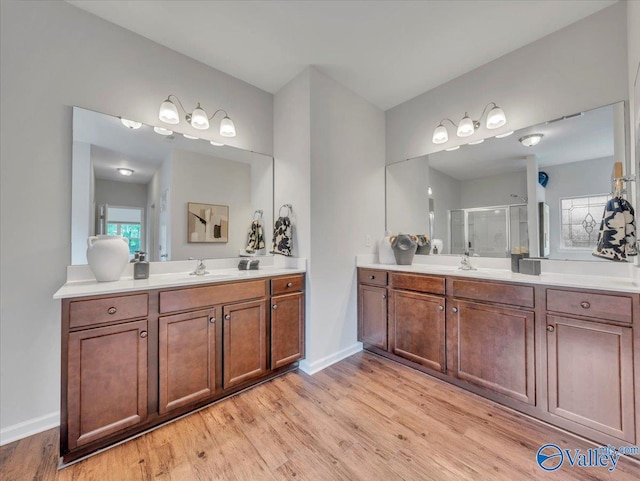 27004 Mill Creek Dr, Athens, AL 35613 - bathroom featuring a shower stall, wood finished floors, two vanities, a sink, and baseboards