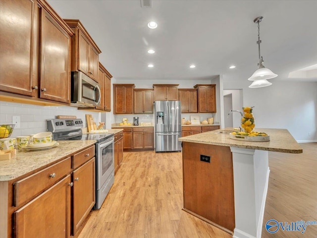 27004 Mill Creek Dr, Athens, AL 35613 - kitchen with a sink, brown cabinetry, stainless steel appliances, and light wood finished floors