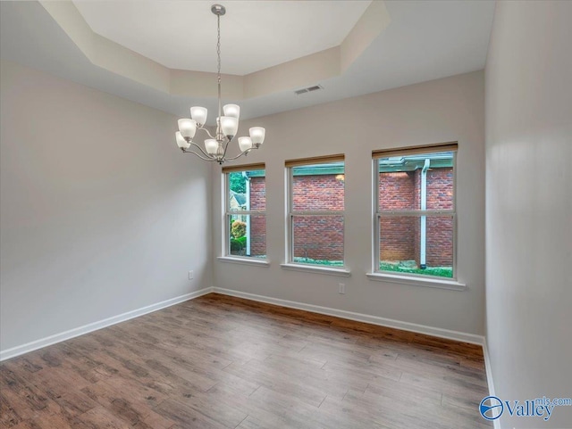 27004 Mill Creek Dr, Athens, AL 35613 - unfurnished room with an inviting chandelier, baseboards, wood finished floors, a tray ceiling, and visible vents