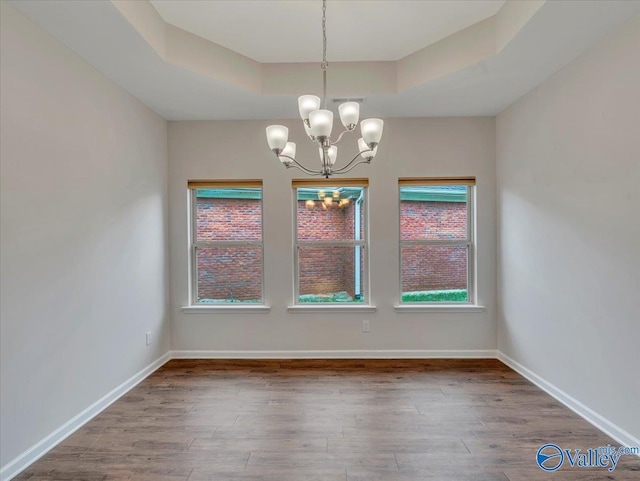 27004 Mill Creek Dr, Athens, AL 35613 - unfurnished dining area with an inviting chandelier, a raised ceiling, baseboards, and wood finished floors