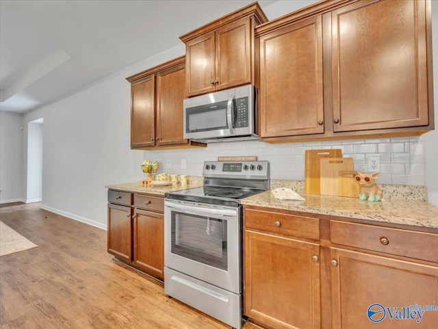 27004 Mill Creek Dr, Athens, AL 35613 - kitchen with baseboards, decorative backsplash, brown cabinetry, and stainless steel appliances