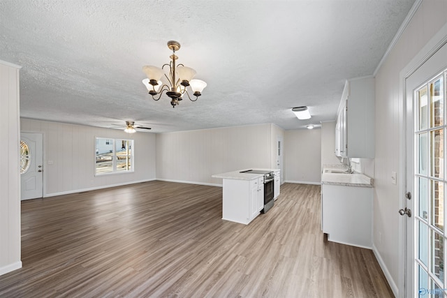 kitchen featuring white cabinets, electric stove, hanging light fixtures, plenty of natural light, and light hardwood / wood-style floors