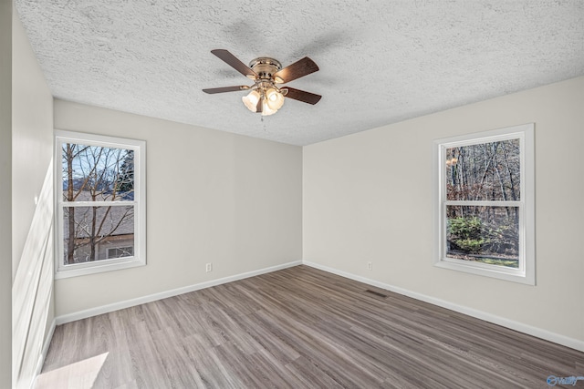 spare room featuring a textured ceiling, hardwood / wood-style flooring, and ceiling fan