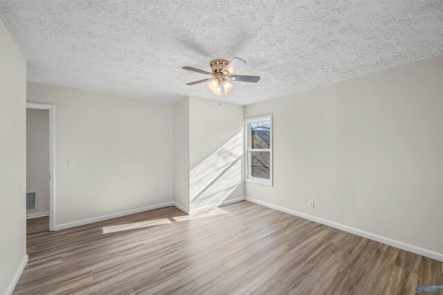 empty room featuring hardwood / wood-style floors, ceiling fan, and a textured ceiling