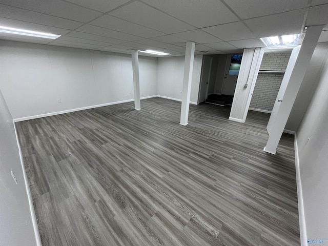 basement with a drop ceiling and dark hardwood / wood-style flooring