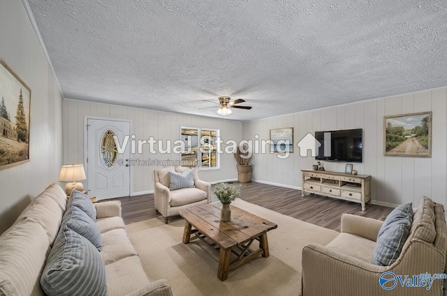 living room with ceiling fan, wood-type flooring, and a textured ceiling