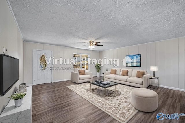 living room featuring a textured ceiling, ceiling fan, wooden walls, and dark hardwood / wood-style floors