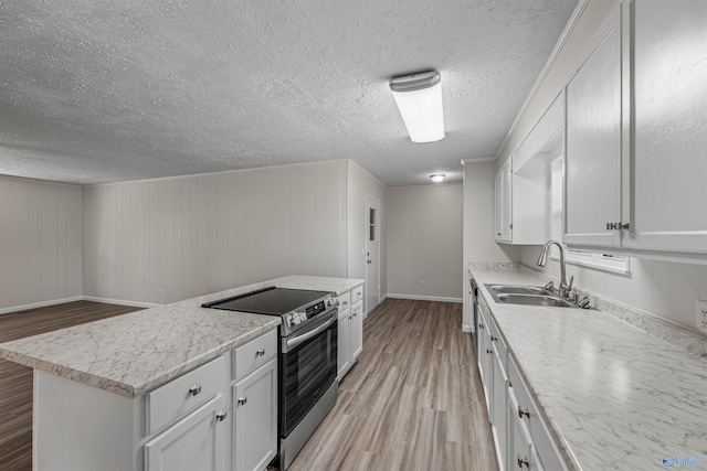 kitchen with stainless steel electric stove, sink, wooden walls, light hardwood / wood-style flooring, and white cabinetry