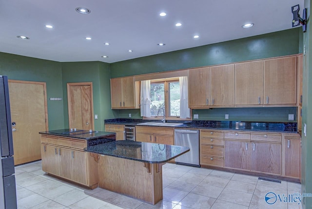 kitchen featuring dark stone countertops, sink, stainless steel dishwasher, and a center island