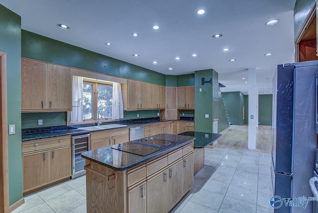 kitchen with wine cooler, sink, a center island, and dark stone countertops