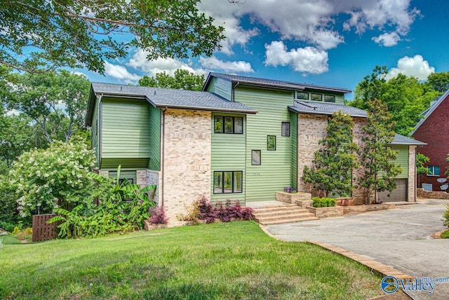 view of front of property featuring a garage and a front lawn