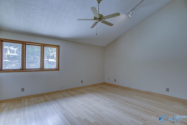 empty room with vaulted ceiling, ceiling fan, a textured ceiling, and light hardwood / wood-style floors