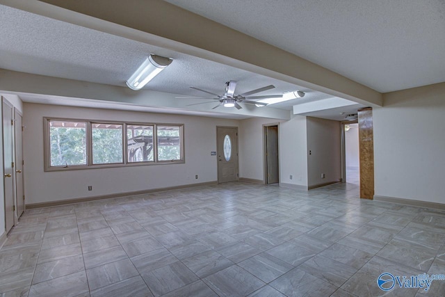 unfurnished living room featuring ceiling fan and a textured ceiling